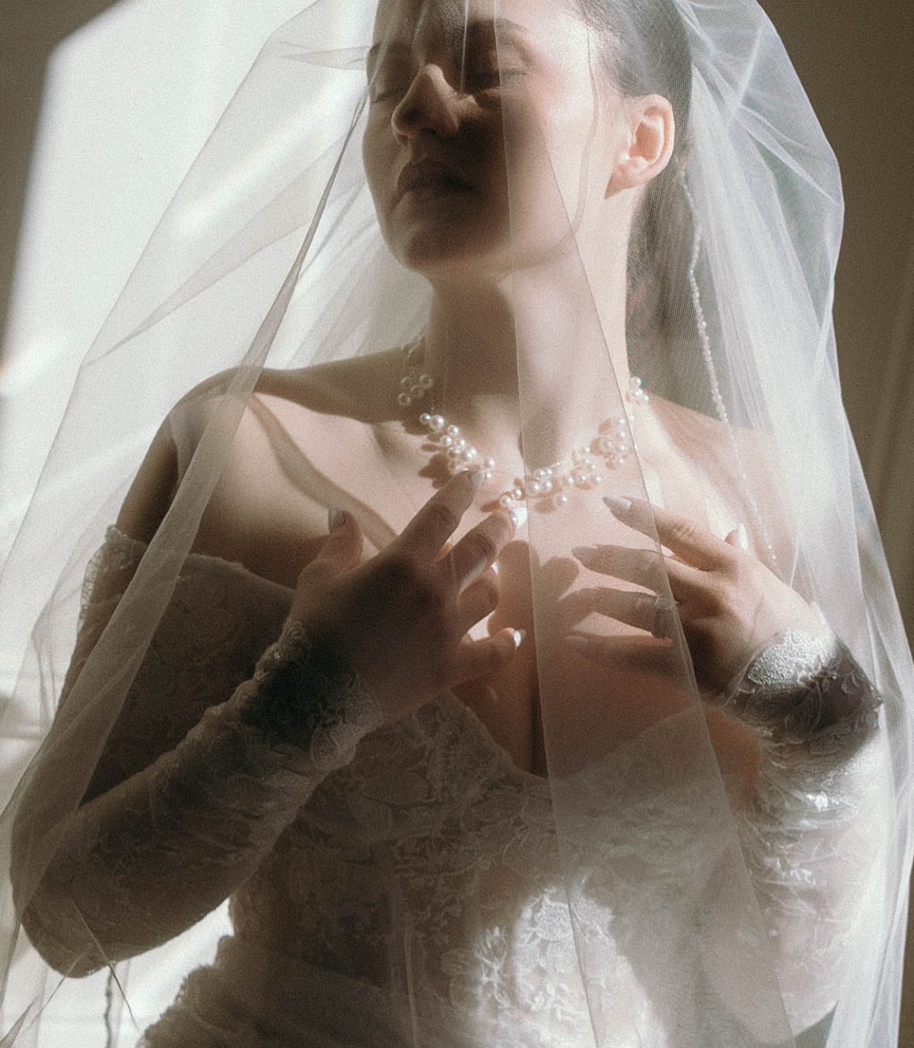 Bride Wearing Floating Pearl Necklace and Vintage Lace Wedding Dress
