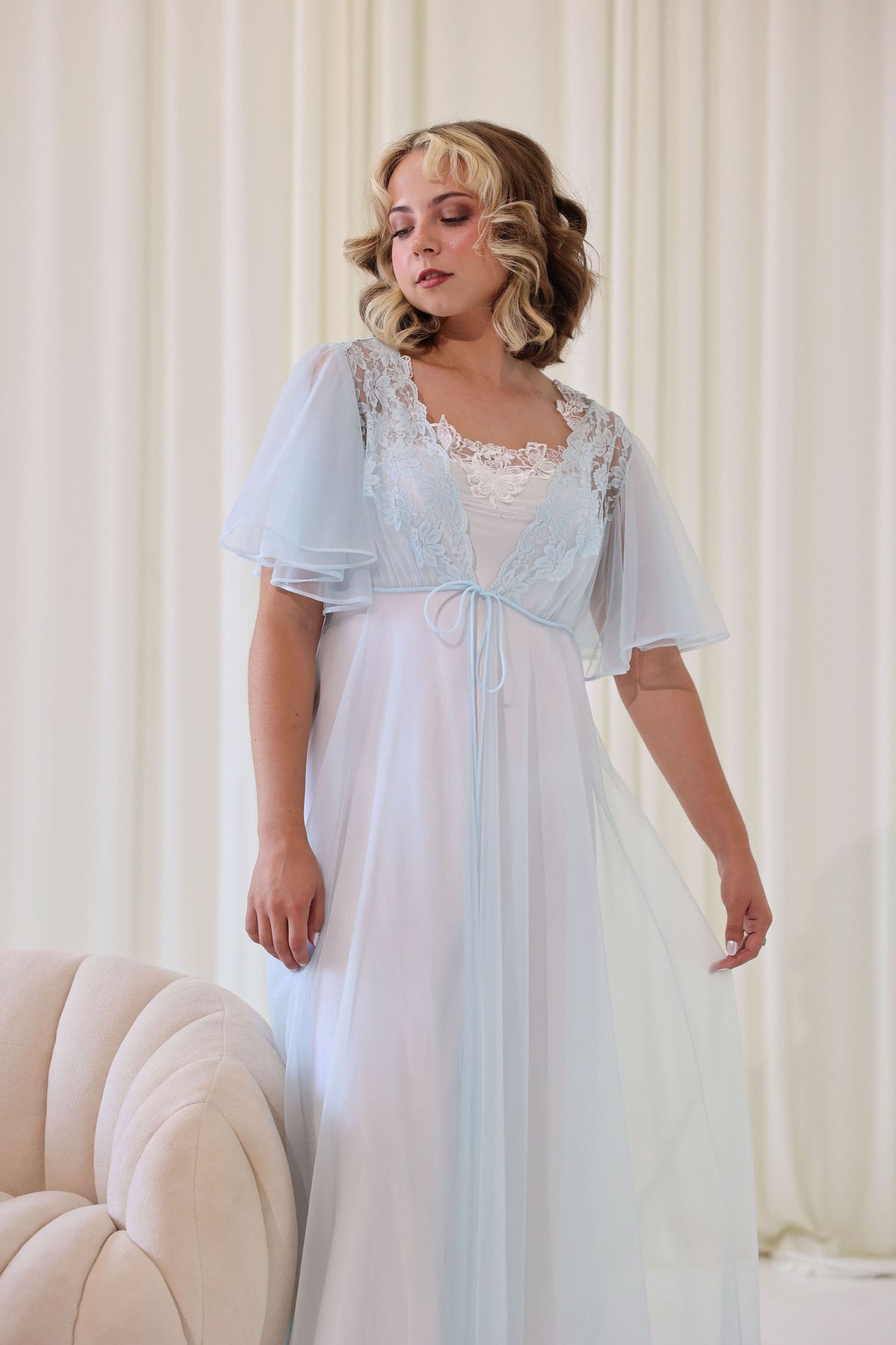 A vintage bridal getting ready outfit with a white slip dress and blue robe