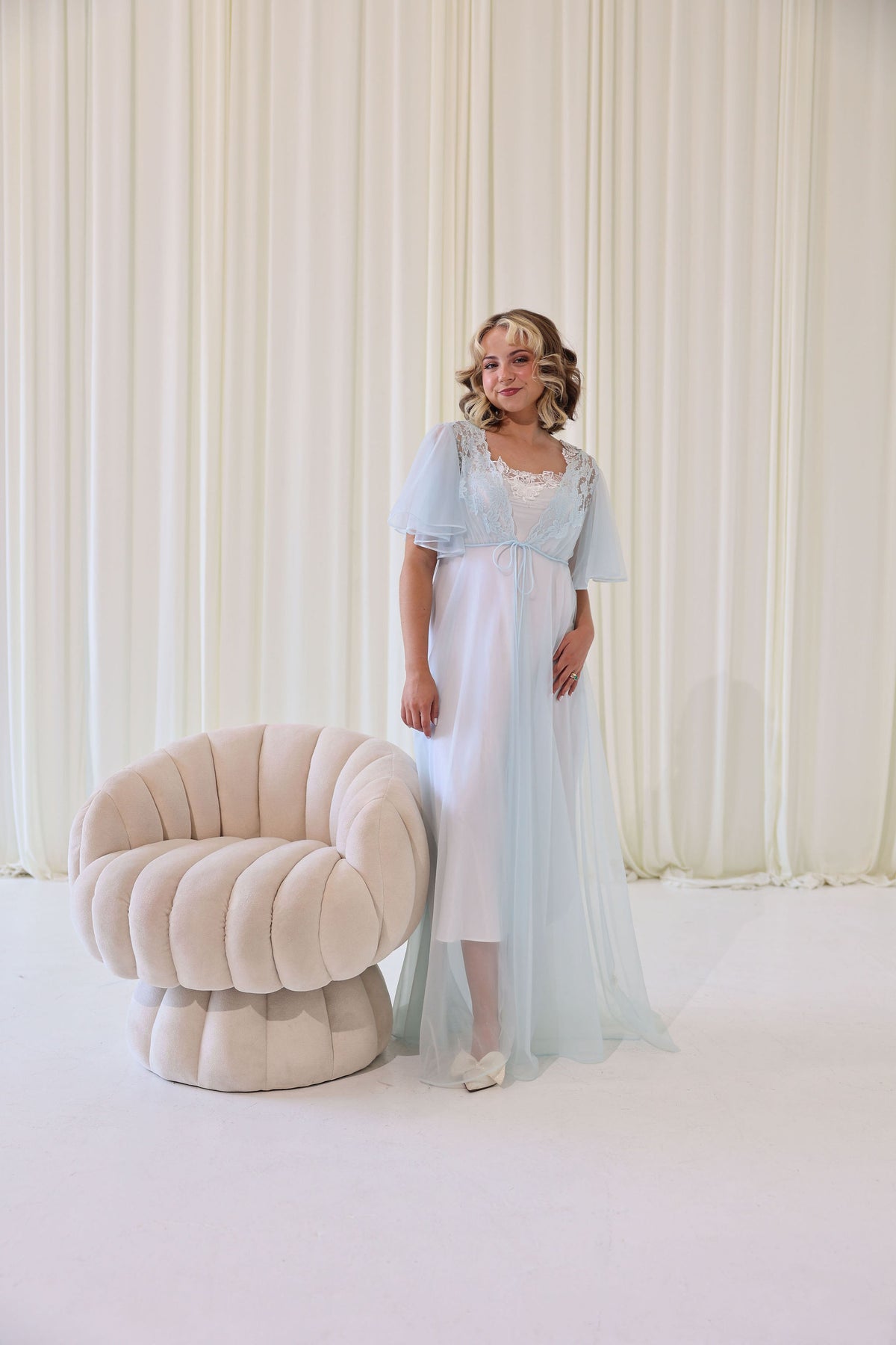 A vintage bridal getting ready outfit with a white slip dress and blue robe